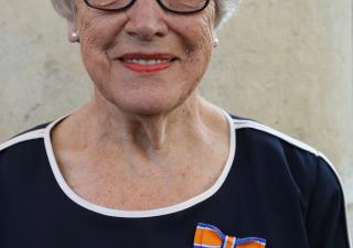 Vrouw met blauwe trui en oranje lintje